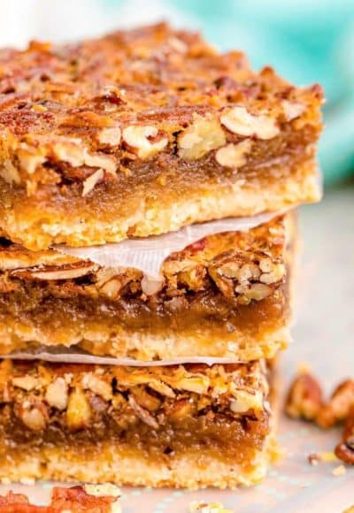 Close up photo of a stack of three pecan pie bars.