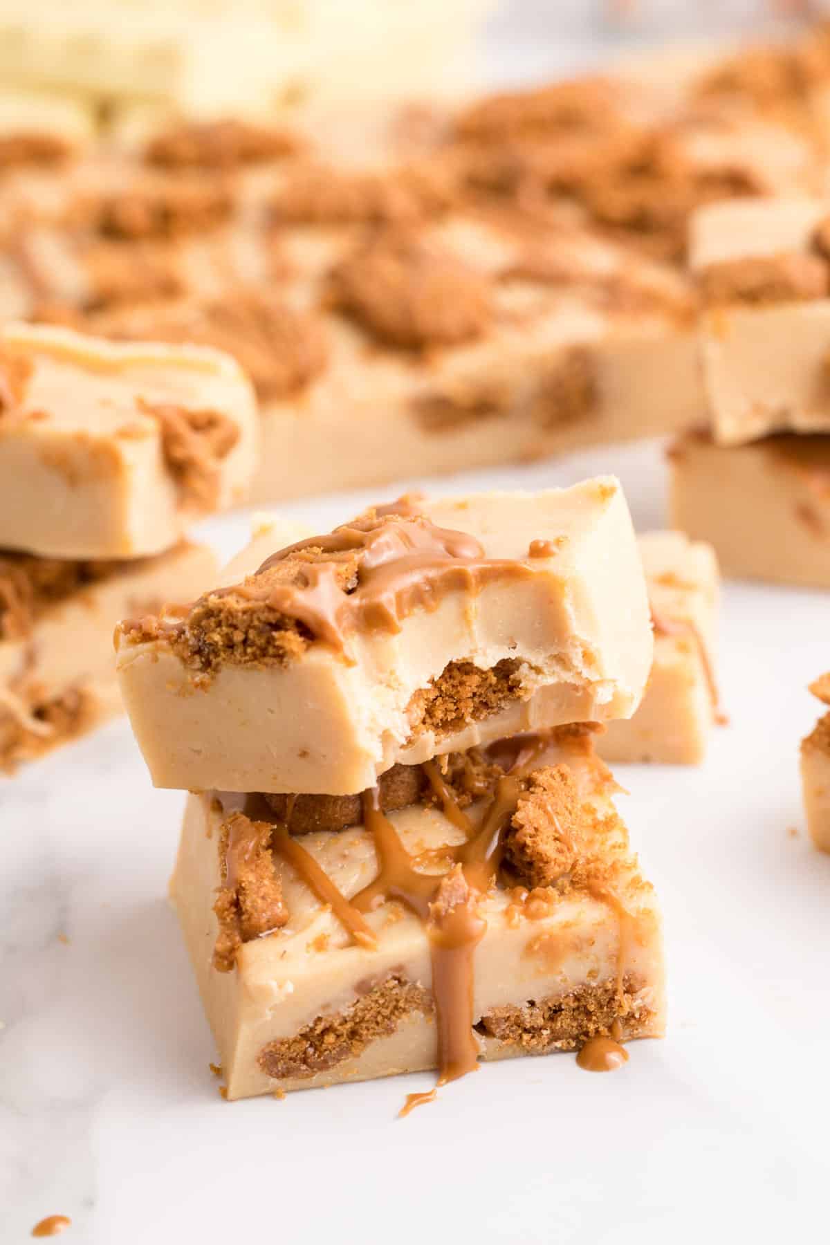 Biscoff fudge stacked with a bite missing from the top one.