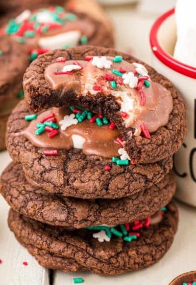 A stack of hot chocolate cookies next to a mug.