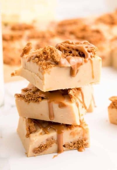 Biscoff fudge stacked three high on a marble surface.