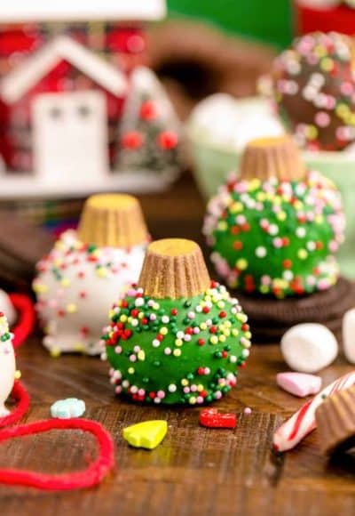 Oreo Ball Ornaments on a wooden table surrounded but holiday decorations.