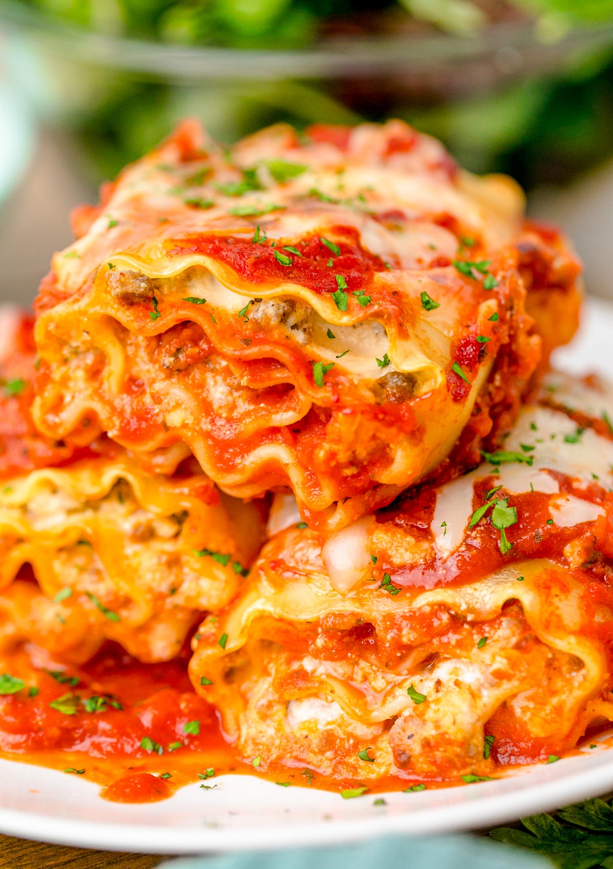 Three Lasagna Roll Ups on a white plate.