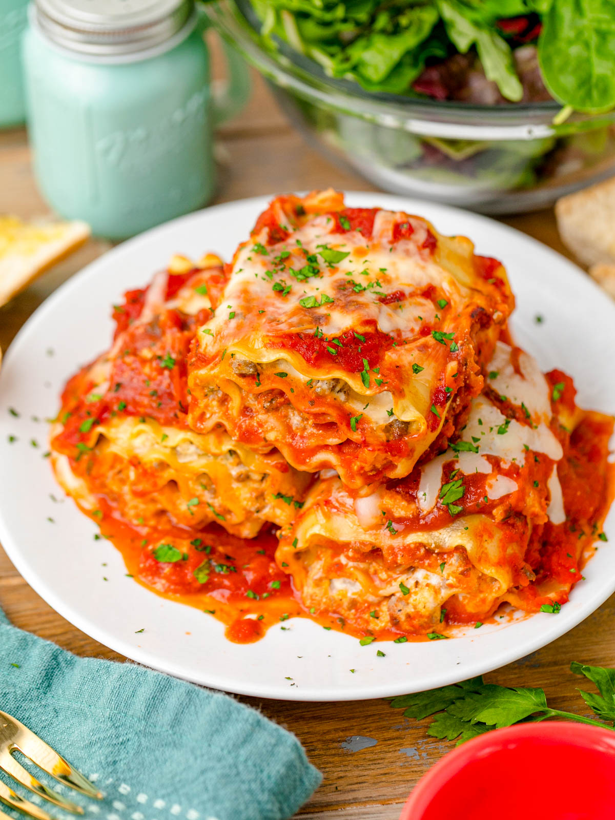 A plate of lasagna roll-ups ready to be eaten at a table.