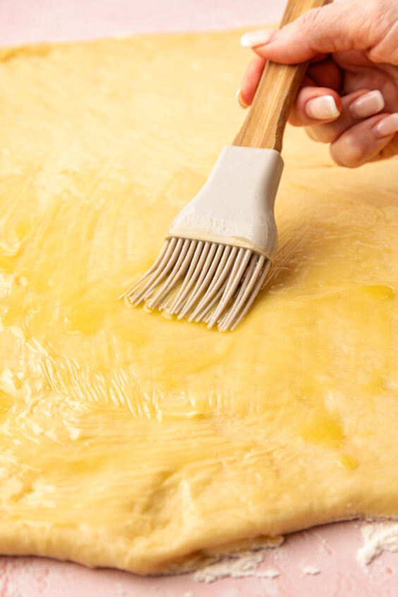 Butter being brushed on dough.