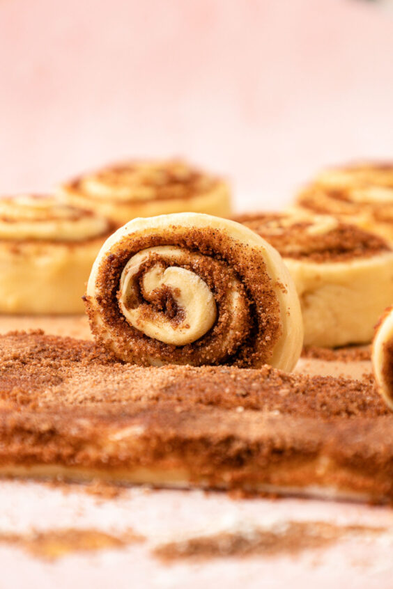 Cinnamon roll strips being rolled up.