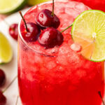 Close up of a glass filled with cherry limeade.