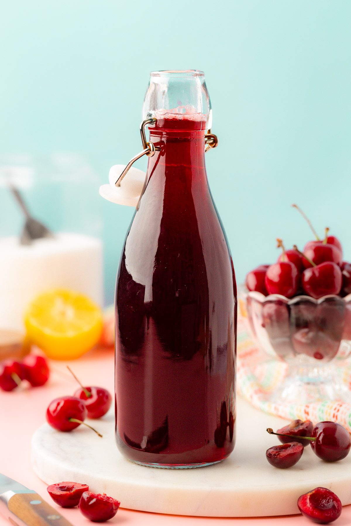 A bottle of cherry simple syrup on a table.