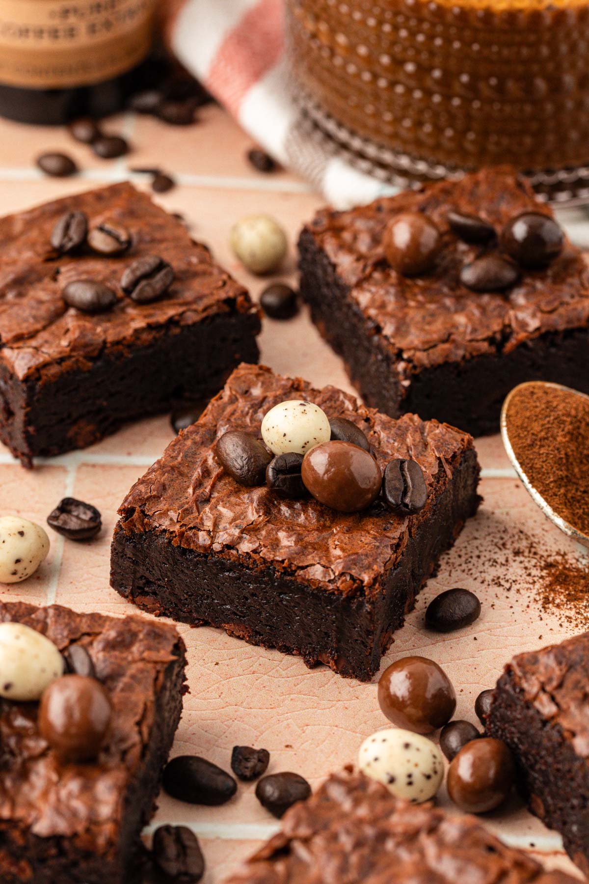 Espresso brownie slices on a table with chocolate covered espresso beans on them.
