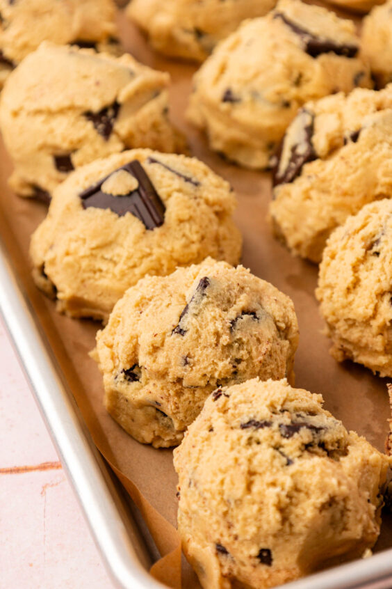 Close up of cookie dough balls on a baking sheet ready to chill.