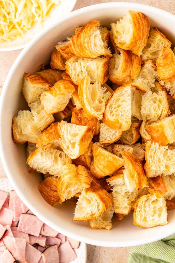 Cubed croissant pieces in a white bowl.