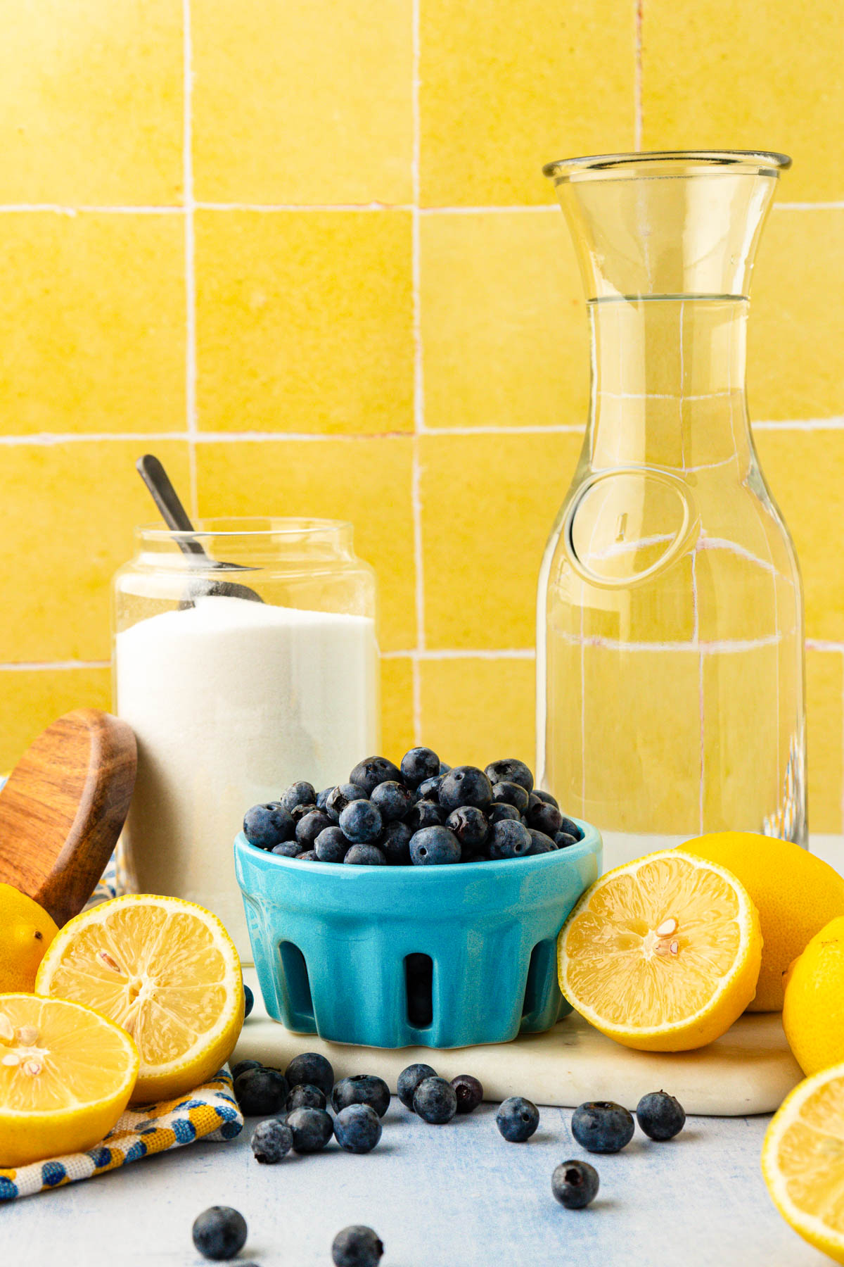 Ingredients to make blueberry lemonade on a table.