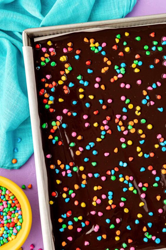 Candy coated chocolate sprinkles on a batch of frosted brownies.