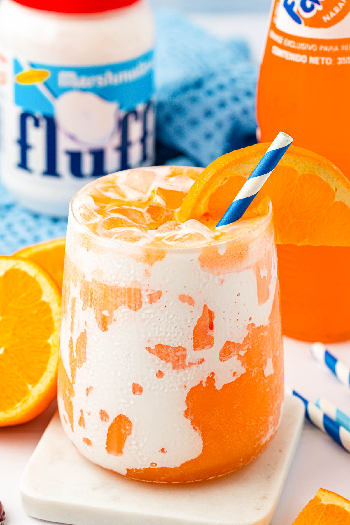 Close up of a Orange Fluffy Soda on a white coaster.