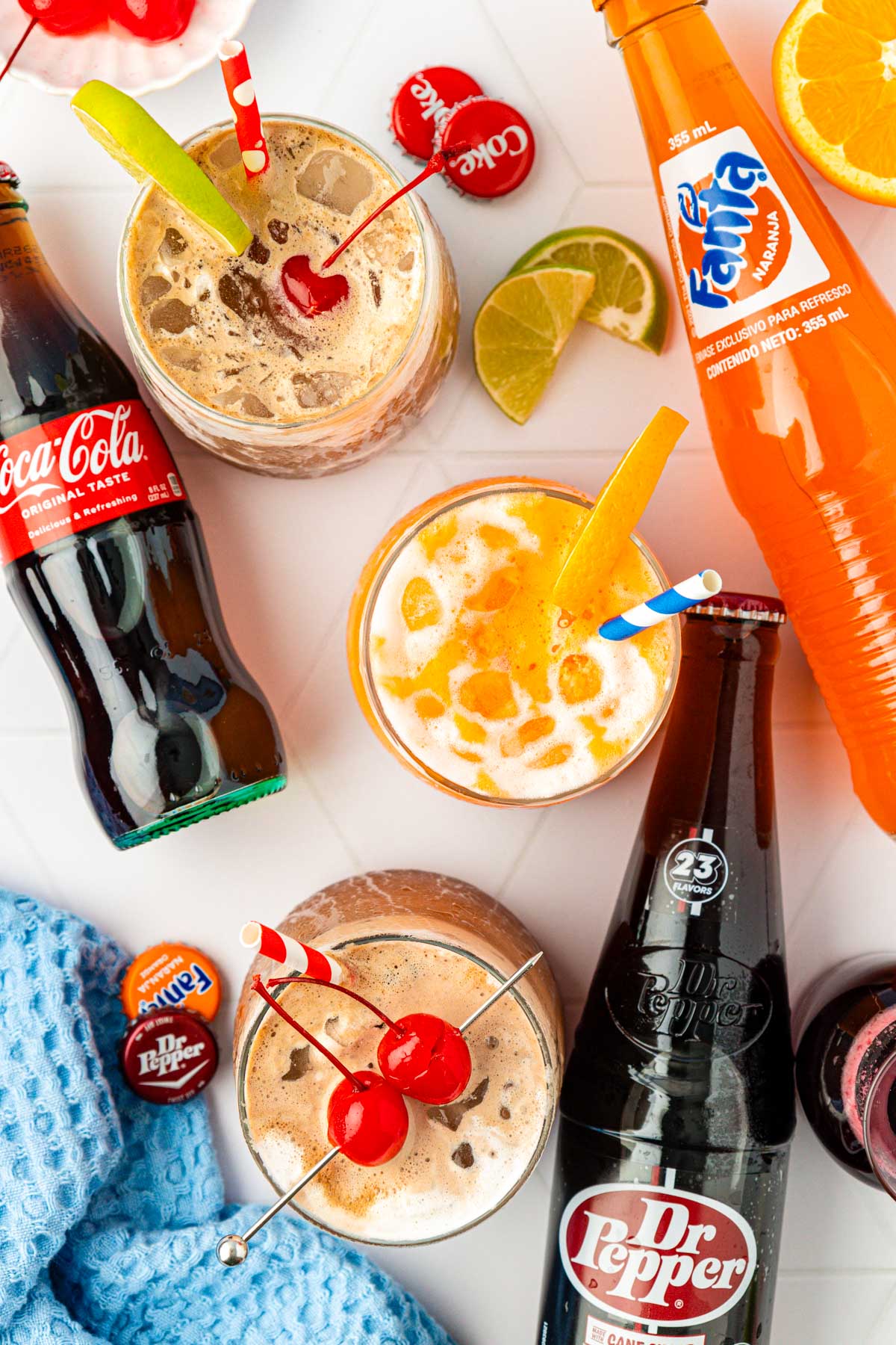 Overhead photo of fluffy sodas and glass bottles of soda on a table.