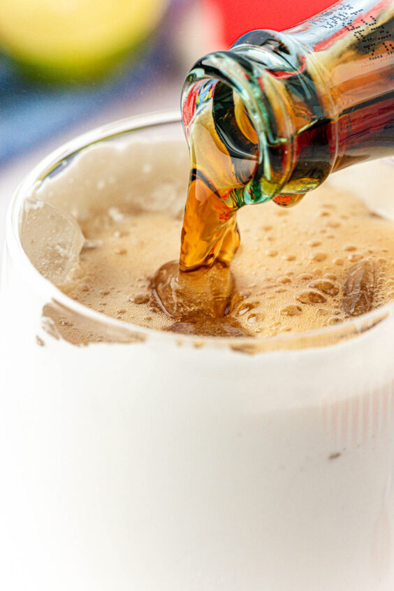 Coke being poured into a glass with fluff.