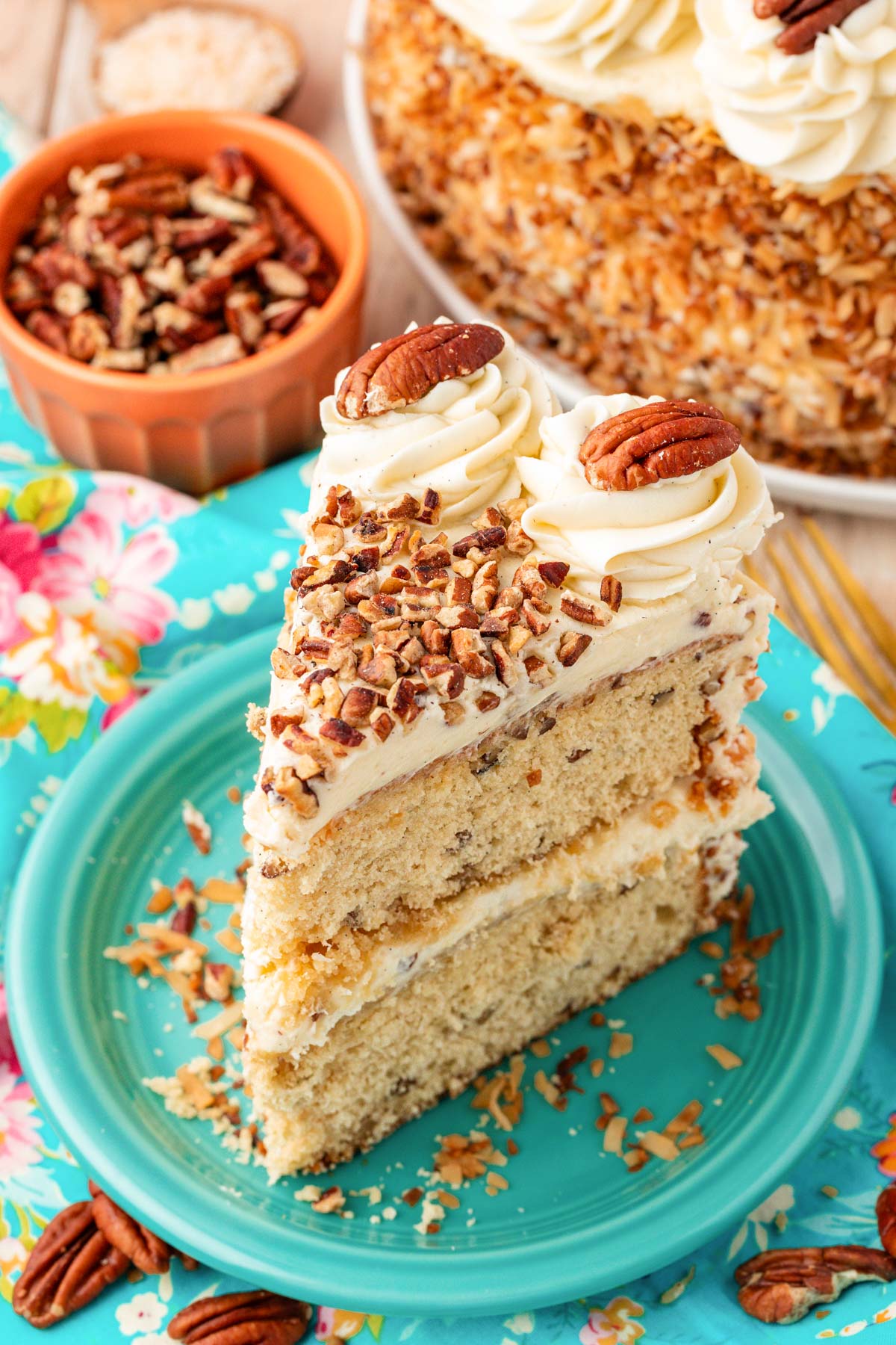 Slice of Italian Cream Cake on a teal plate. 