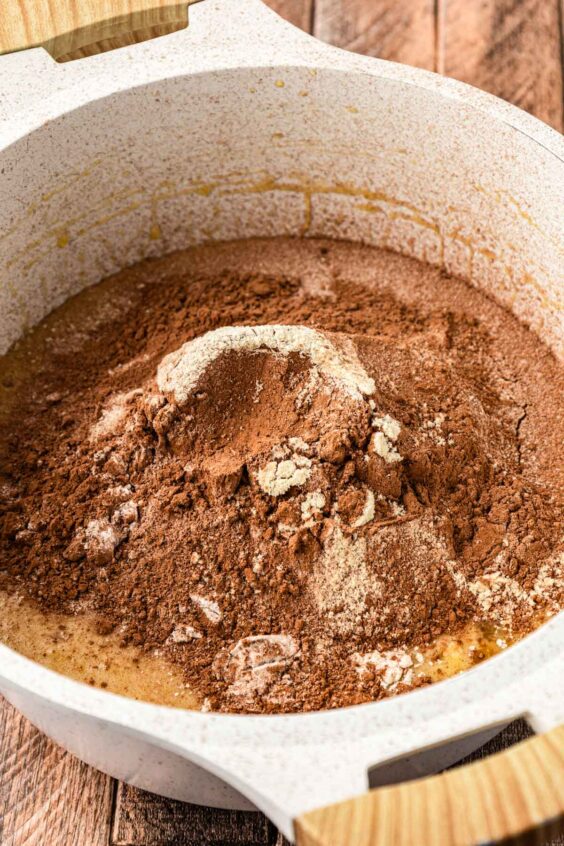 Cocoa powder and flour sifted into a pot to make brownie batter.