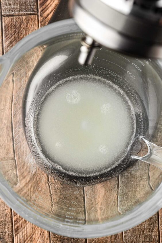 Gelatin and water in a glass stand mixer bowl.