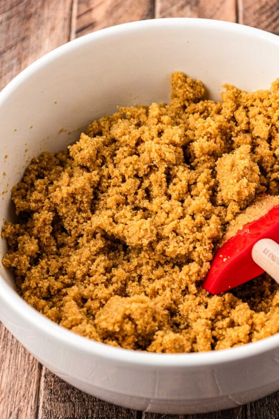 Graham cracker crumb crust being mixed in a bowl.