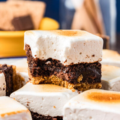 S'mores Brownies on a table, one stacked on top of another with a bite missing from it.