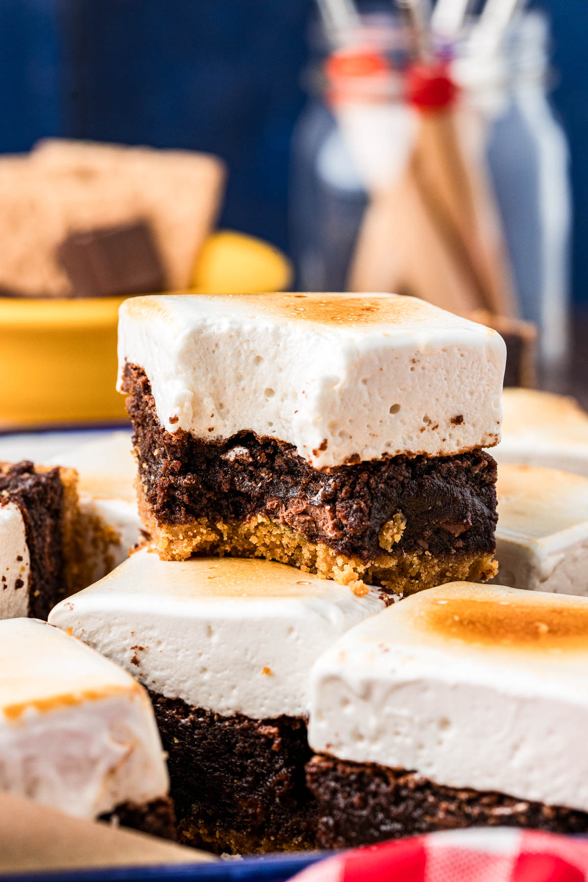 S'mores Brownies on a table, one stacked on top of another with a bite missing from it.