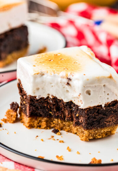 Close up of a s'mores brownie on a plate with a bite missing.