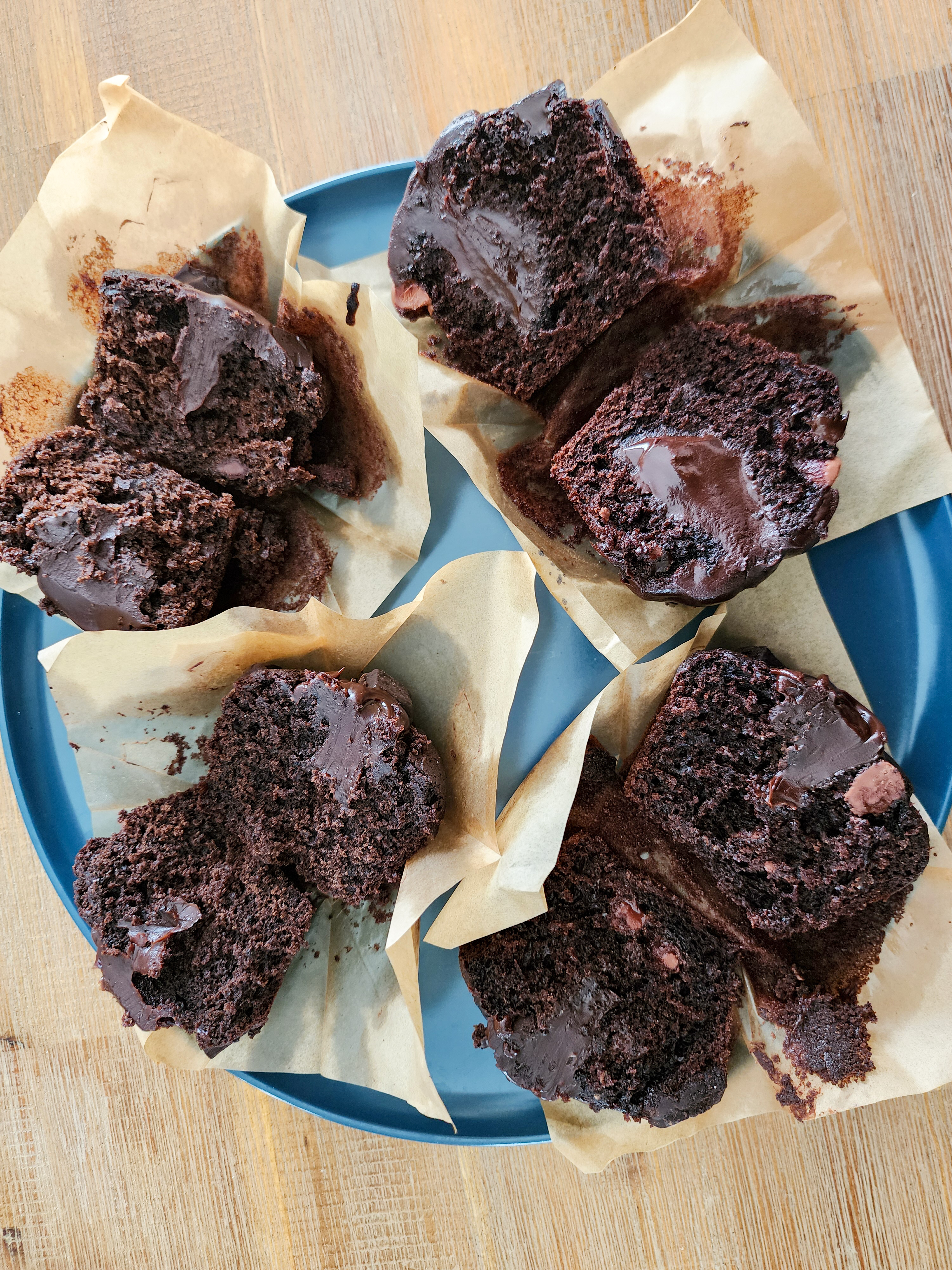 Four chocolate muffins cut in half on a blue plate.