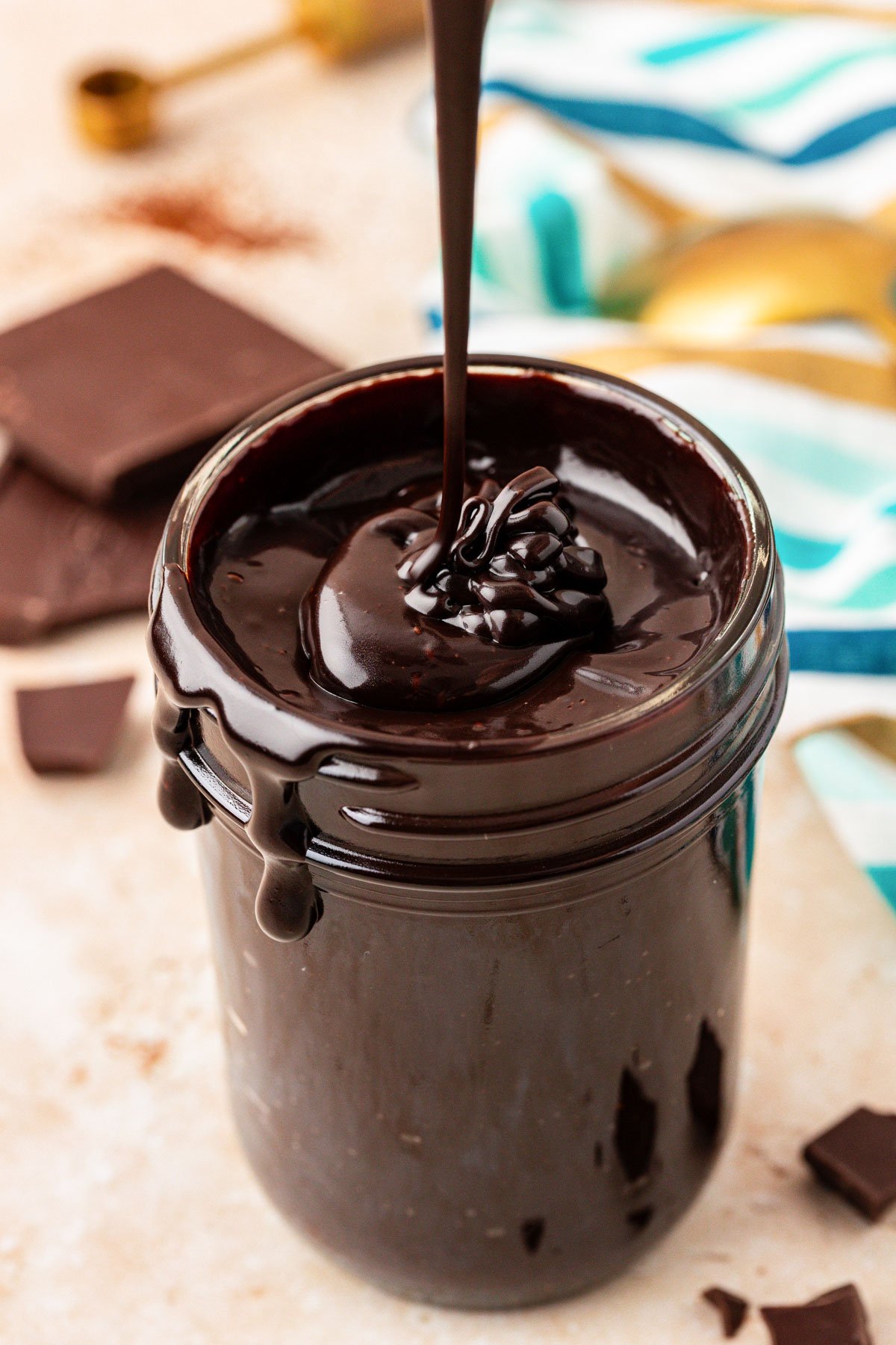 Hot fudge being drizzled into a jar.