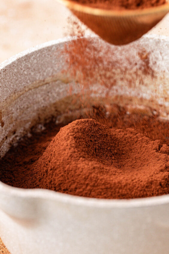 Cocoa being sifted into a pot.