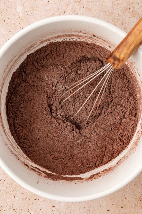 Dry ingredients for chocolate muffins being whisked in a bowl.