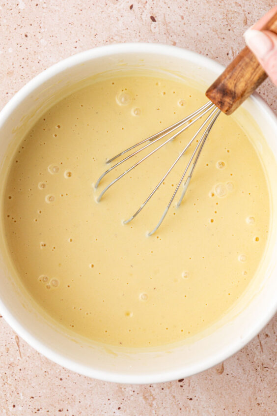 Muffin batter being whisked in a bowl.