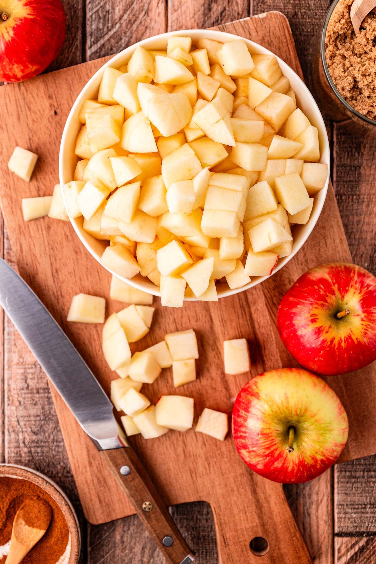 Overhead photo of apples being chopped on a cutting board.