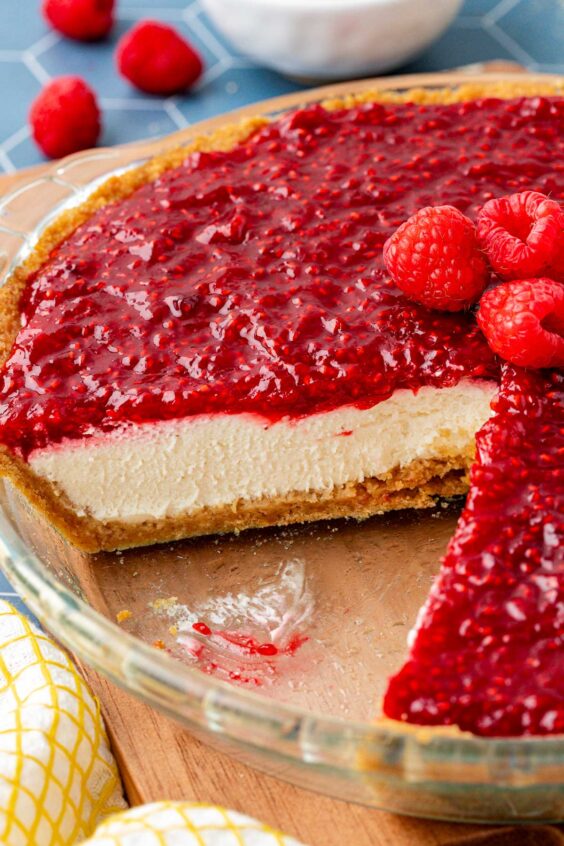 Close up of a raspberry cream pie with slices missing from the dish.