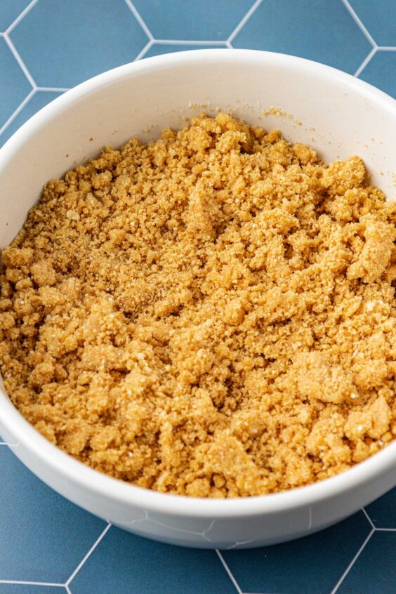 Graham cracker crust mixture in a white bowl.