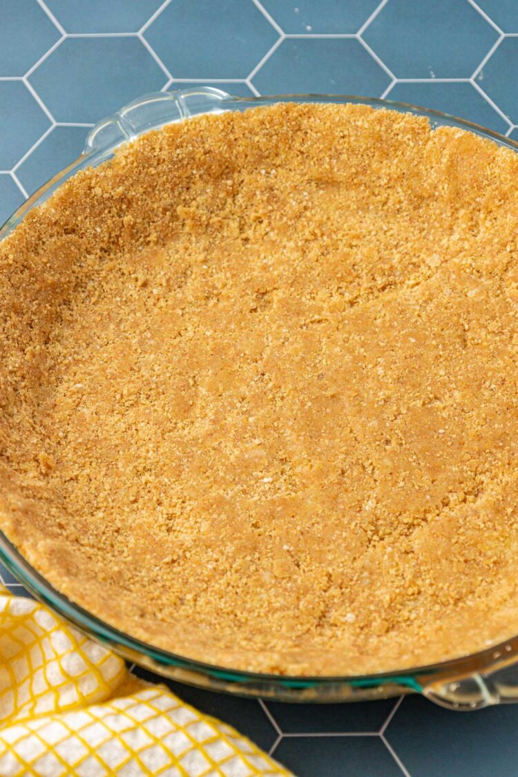 Graham cracker pie crust on a blue table.