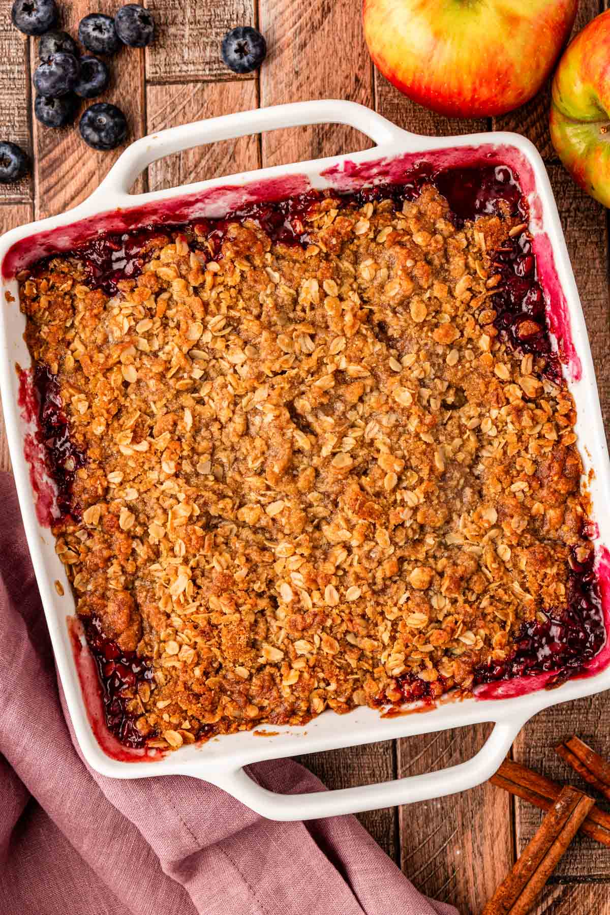 Overhead photo of apple blueberry crisp on a wooden table.