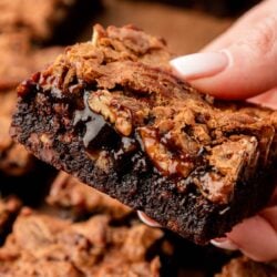 Close up of pecan pie brownies in a woman's hand.