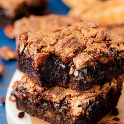 Close up of pecan pie brownies stacked on a plate.