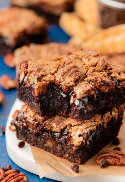 Close up of pecan pie brownies stacked on a plate.