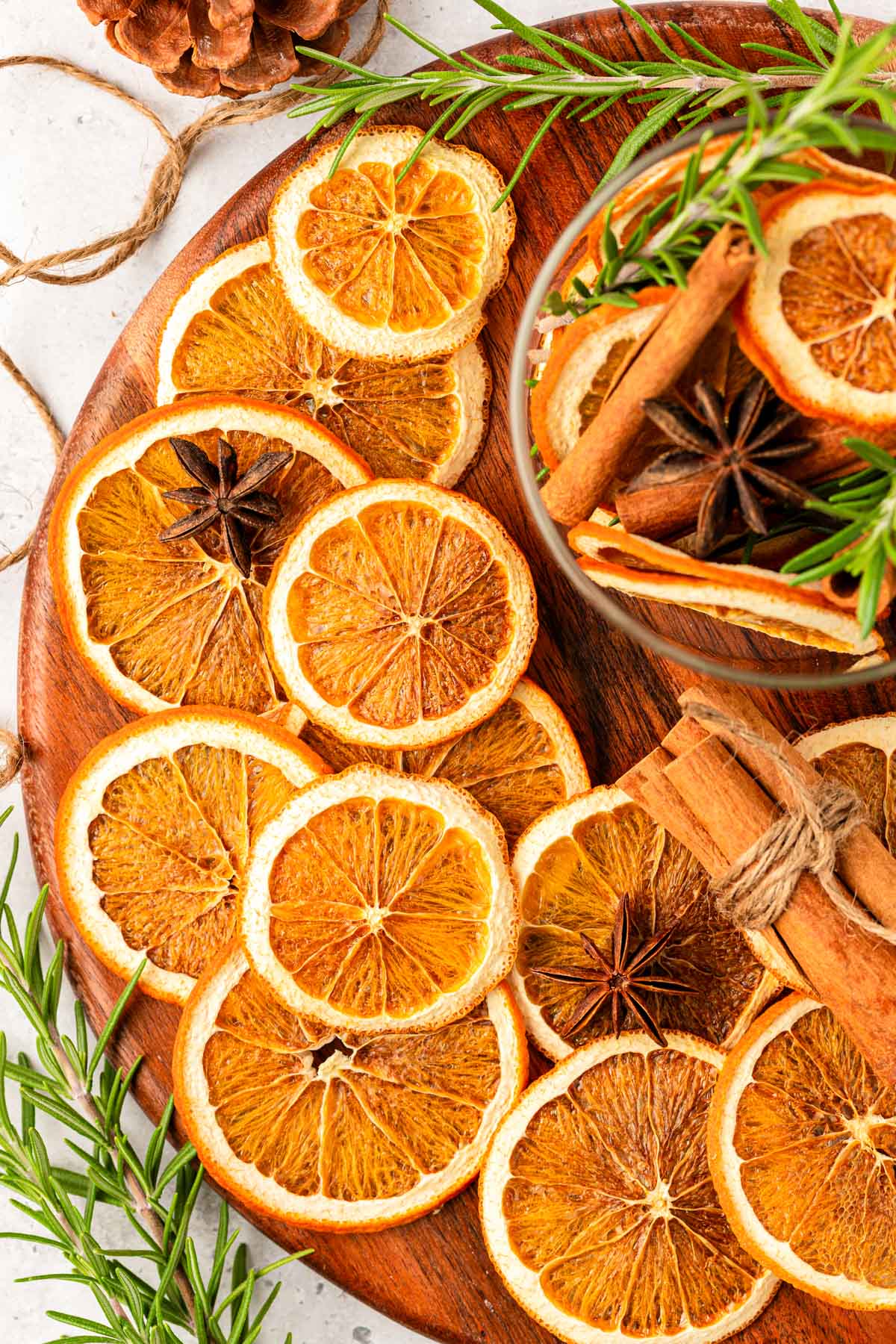 Overhead photo of sliced dried oranges on a wooden board.