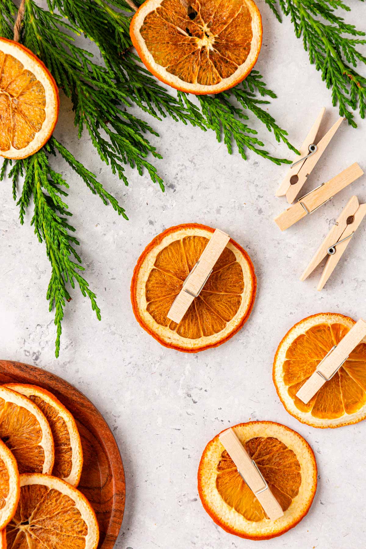 Clothespins being glued onto dried orange slices.