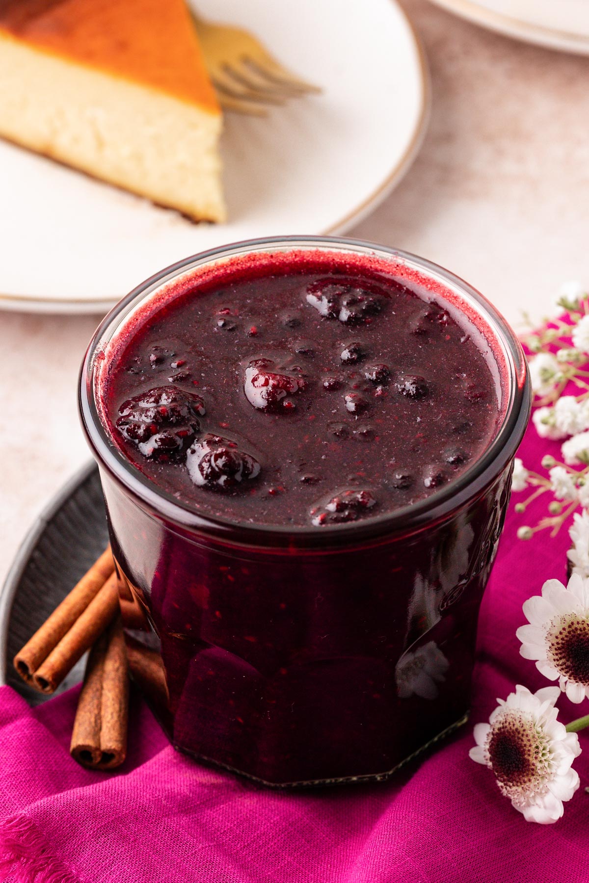 A jar of berry compote on a pink napkin.