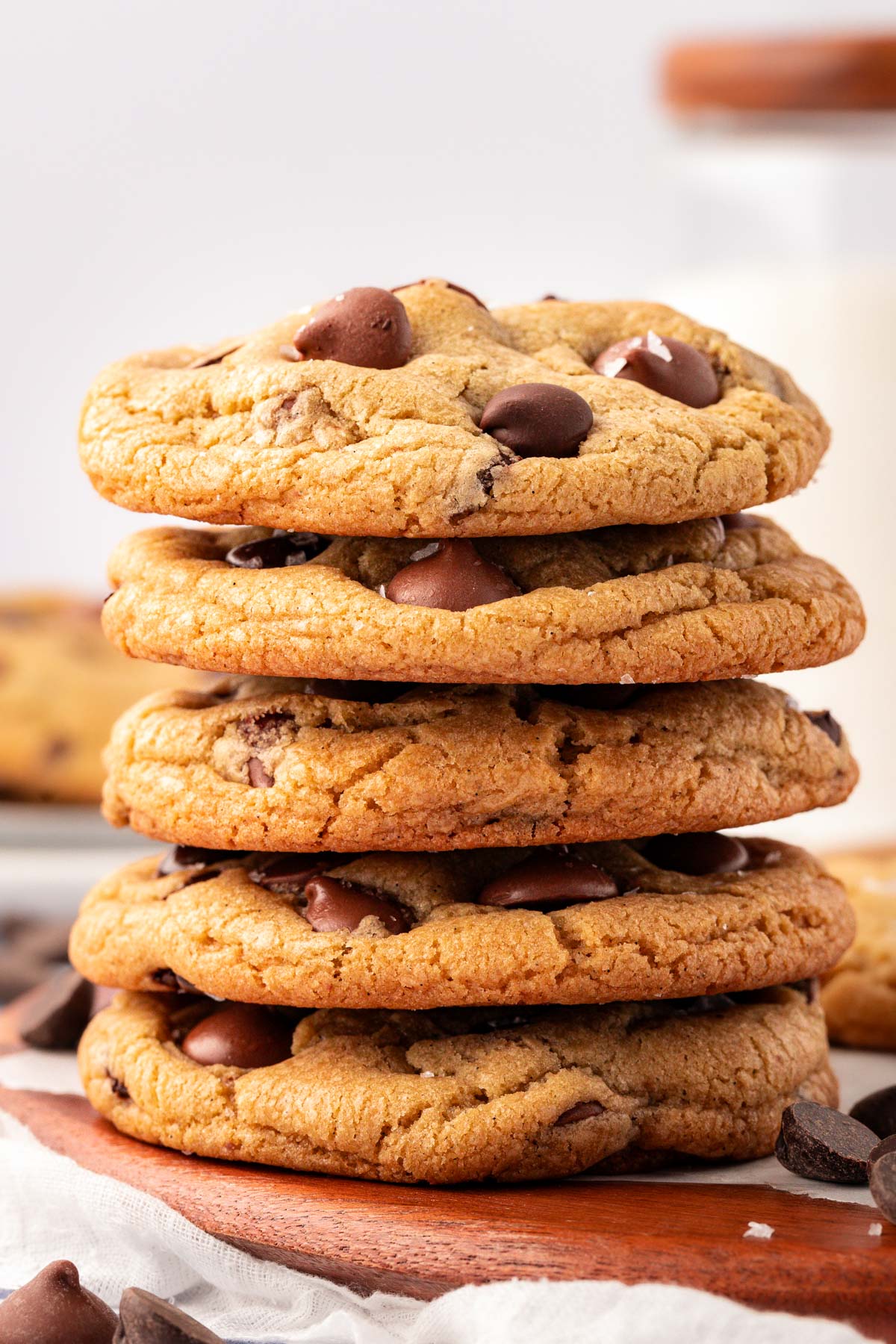 A stack of 5 chocolate chip cookies on a table.