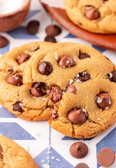 Close up of chocolate chip cookies on a table, one is missing a bite.