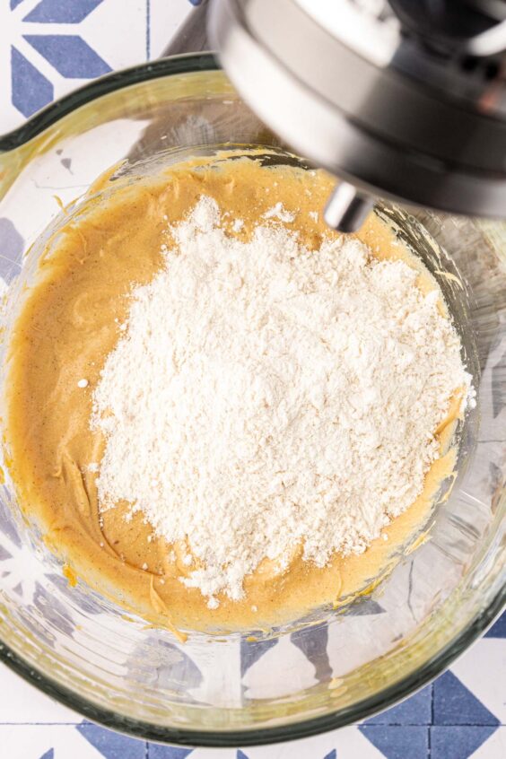 Dry ingredients being added to wet ingredients in a mixing bowl.