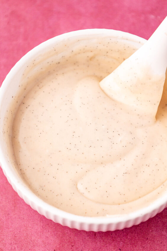 Vanilla icing in a white bowl.