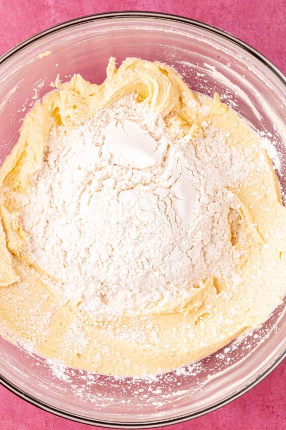 Dry ingredients being added to wet ingredients in a bowl.