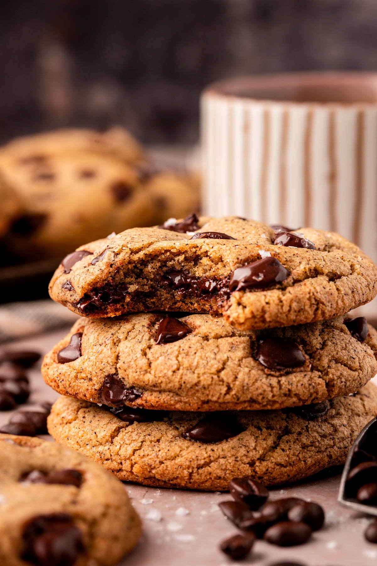 Close up of a stack of three chocolate chip cookies. The top one is missing a bite.