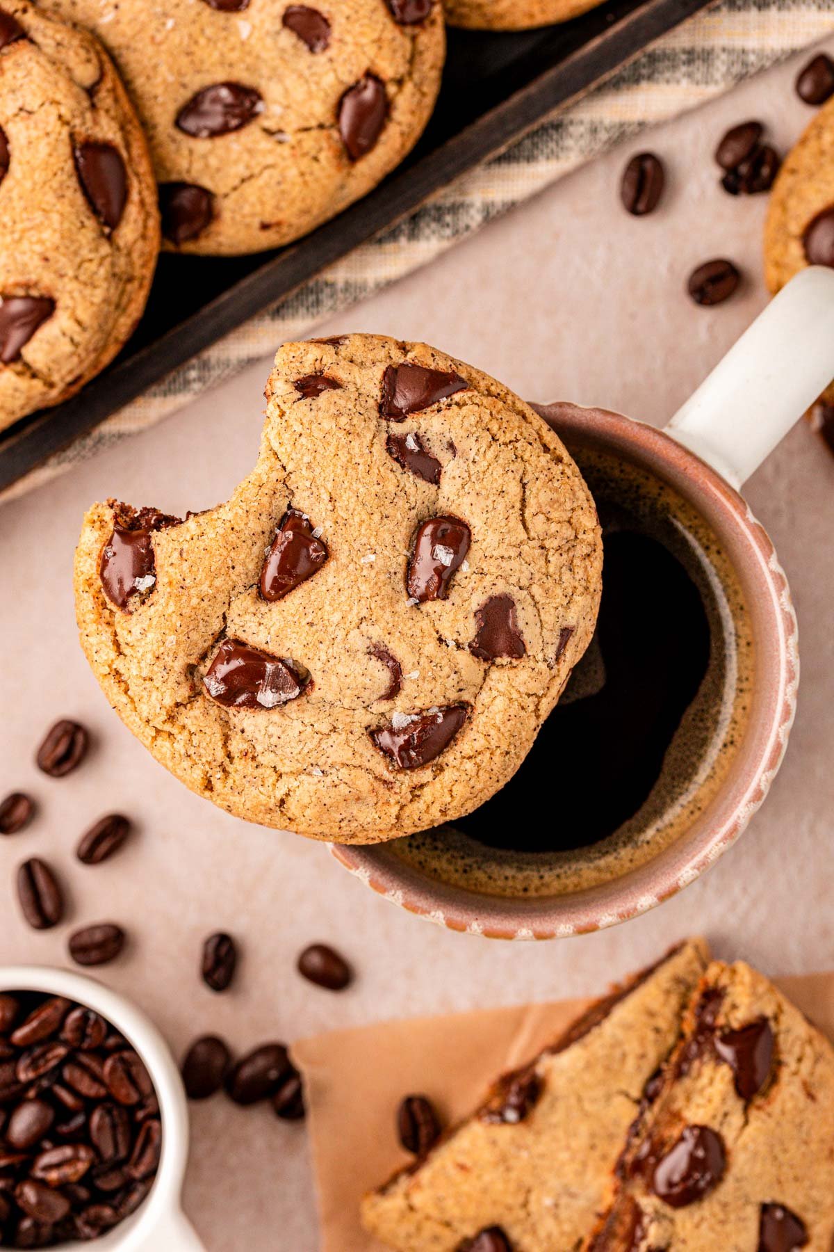 Overhead photo of an espresso chip cookie on a mug with a bite missing.