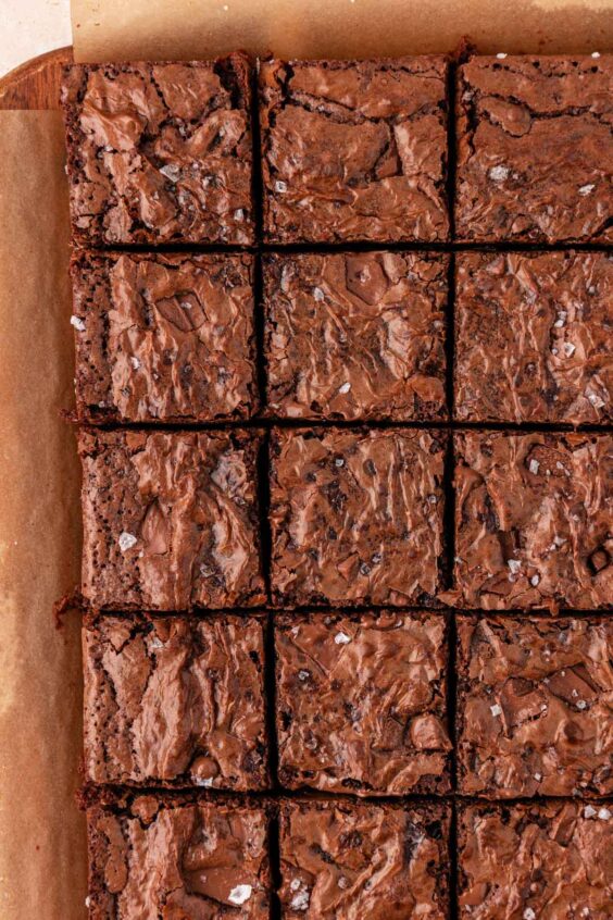 Sliced chocolate chunk brownies on a piece of parchment paper.